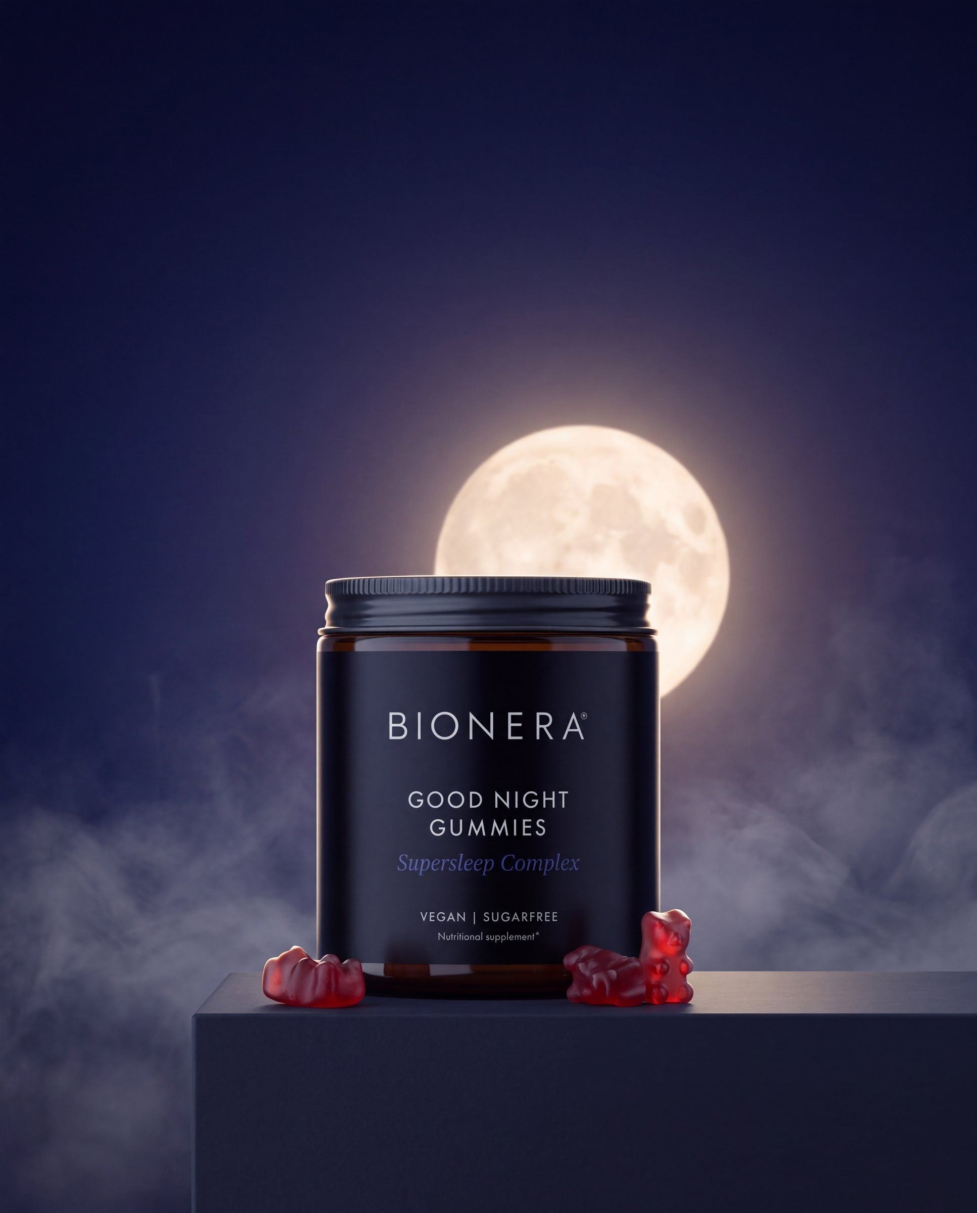Pot Good Night Gummies op een donkere sokkel voor een volle maan in nachtblauwe nevel